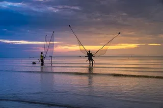 两名男子在海里拿着网的照片