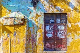 黄色、白色和青色漆的混凝土墙，带红色木制双门窗