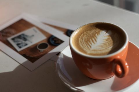 茶托上橙色陶瓷杯中的咖啡