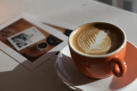 茶托上橙色陶瓷杯中的咖啡 茶托上橙色陶瓷杯中的咖啡