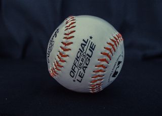 黑色织物上的白色和橙色官方棒球联盟