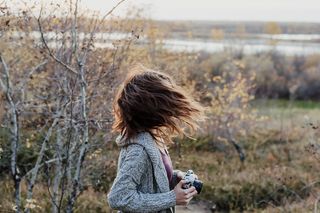 一名女子拿着相机挥舞着头发的照片