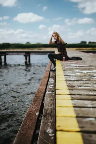 湖边一个木码头上美丽的金发女人