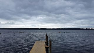 在暴风雨的天空下，卡亚尔人在马纳斯坎水库的水面上划水。