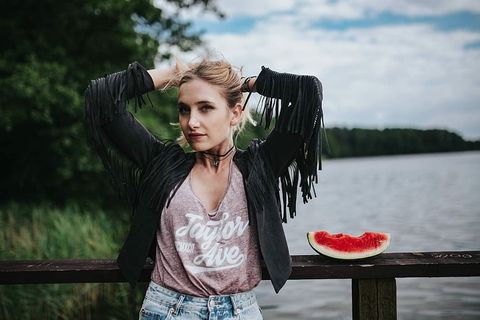 金发女人在木码头吃健康零食 金发女人在木码头吃健康零食