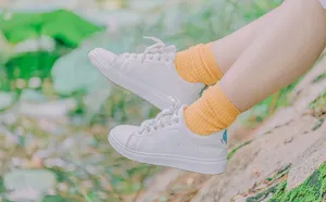 穿着白色低帮运动鞋和橙色圆领袜的人