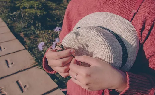 穿着毛衣拿着花和帽子的人 穿着毛衣拿着花和帽子的人