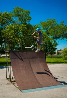 在棕色木制滑板坡道上玩滑板车的男子