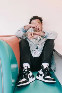 坐在绿色和棕色椅子上的男子