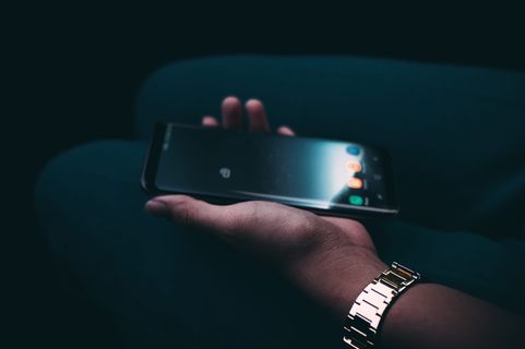 手持黑色安卓智能手机的人