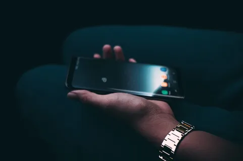 手持黑色安卓智能手机的人