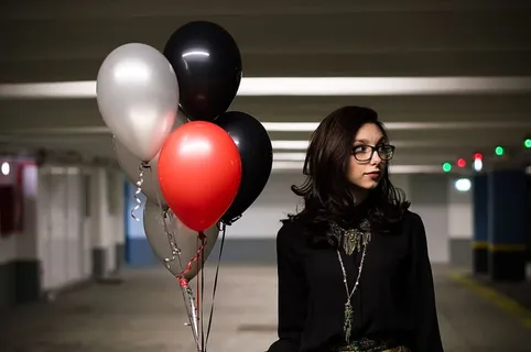 女士,戴,眼镜,黑色,上衣,手持,气球,停车场 女士,戴,眼镜,黑色,上衣,手持,气球,停车场