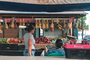两名妇女面对水果和蔬菜摊位