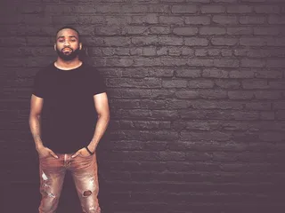 站在砖墙前的男子