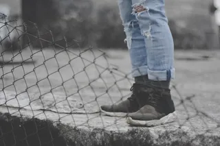 钻石栅栏旁穿着黑色跑鞋的人