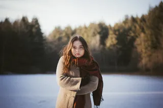 穿着棕色外套和红色围巾的女人