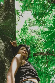一个女人靠在树上的照片 一个女人靠在树上的照片