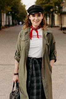 白天，一名妇女站在建筑物之间的灰色人行道上