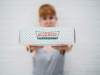 展示Krispy Kreme盒子的女人