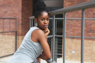 女人倚靠在灰色的金属框架上