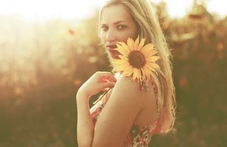 日落时抱着向日葵的女人