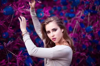 拿着紫色和蓝色花朵的女人