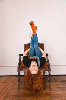 倒立在木椅上的女人的照片