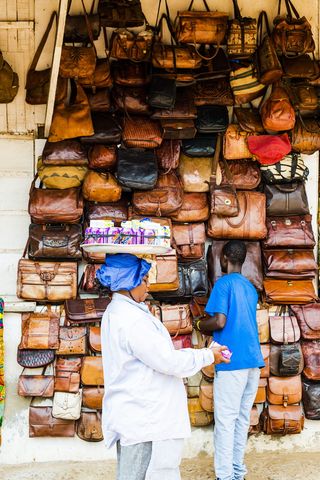 站在棕色皮包场地旁的男子
