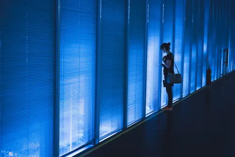 一名妇女站在蓝色Led墙附近