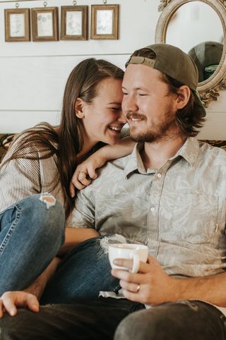 一对夫妇坐在沙发上，靠近棕色木框镜子