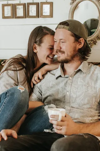 一对夫妇坐在沙发上，靠近棕色木框镜子