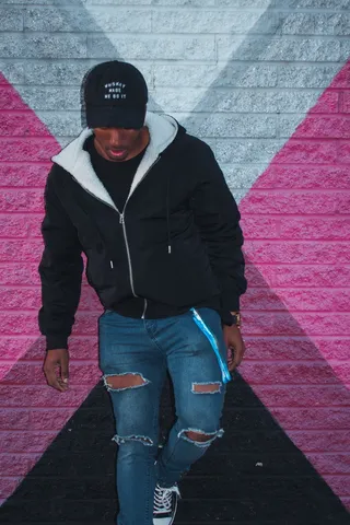 靠在粉红色和白色墙壁前的男人