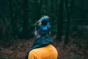 一位身穿橙色上衣、戴着围巾的女士