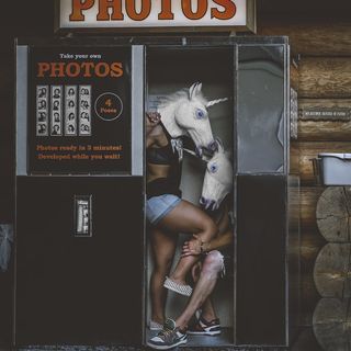 照片亭里两个穿着独角兽头饰的人