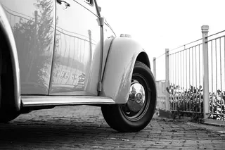 白色金属栅栏附近的白色大众甲壳虫