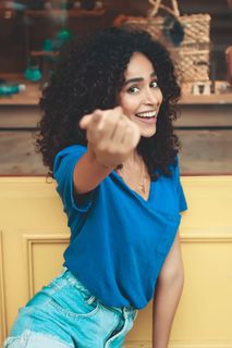 身穿蓝色上衣和蓝色牛仔裤的微笑女性