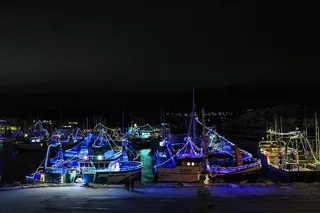 加拿大纽芬兰和拉布拉多德格雷夫港——2017年12月22日。2017年12月22日，在德格雷夫港拍摄的夜晚用灯光庆祝圣诞节的渔船。