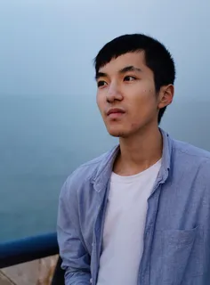 一名男子坐在灰色表面附近