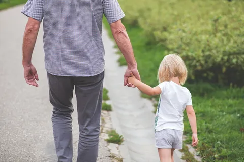 白天在灌木丛附近散步的男人和孩子 白天在灌木丛附近散步的男人和孩子