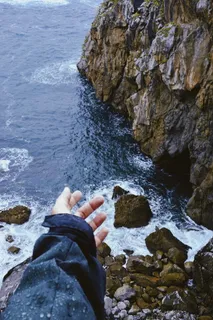 站在岩石峭壁上面向大海的人 站在岩石峭壁上面向大海的人