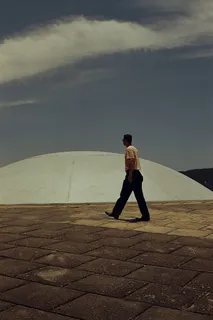 一名男子在石头圆顶附近行走的照片