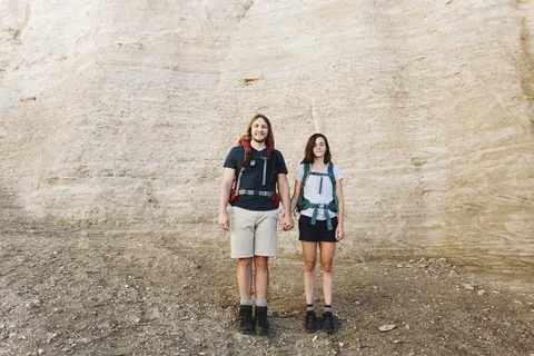 站在岩石山脉上女人旁边的男人 站在岩石山脉上女人旁边的男人