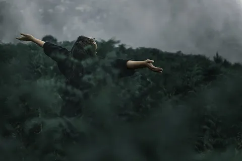 站在草地上张开双手的人