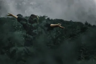 站在草地上张开双手的人