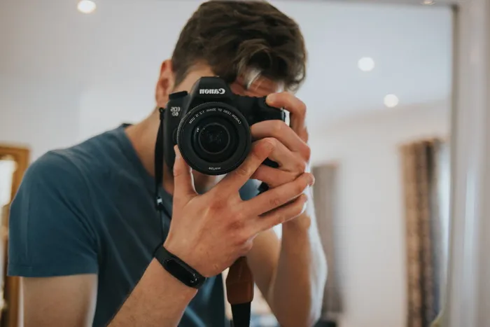 男子使用黑白佳能EOS单反相机