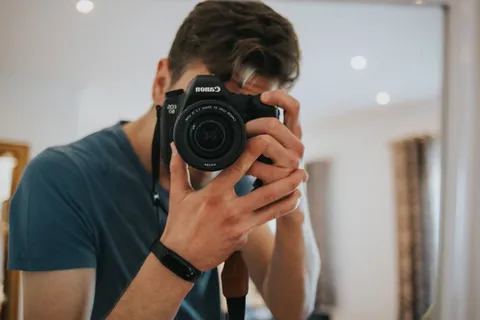 男子使用黑白佳能EOS单反相机