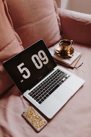 在粉色沙发上放着笔记本电脑的工作场所