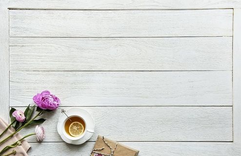 白色陶瓷杯旁的粉色花朵