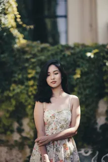 站在被植物覆盖的墙前的女人 站在被植物覆盖的墙前的女人
