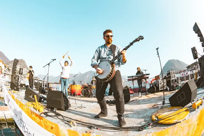 站在麦克风前的人旁边弹奏班卓琴的人